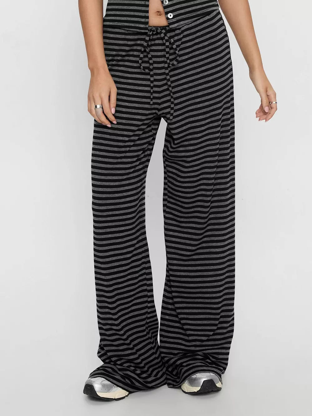 Striped wide-leg pants with drawstring waist and button-down detail.