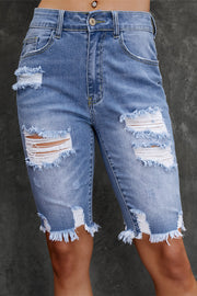 Light wash denim bermuda shorts with ripped knees and frayed hem