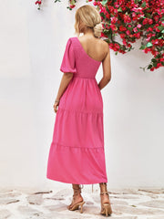 Hot pink smocked bodice tiered one-shoulder dress with puff sleeve.