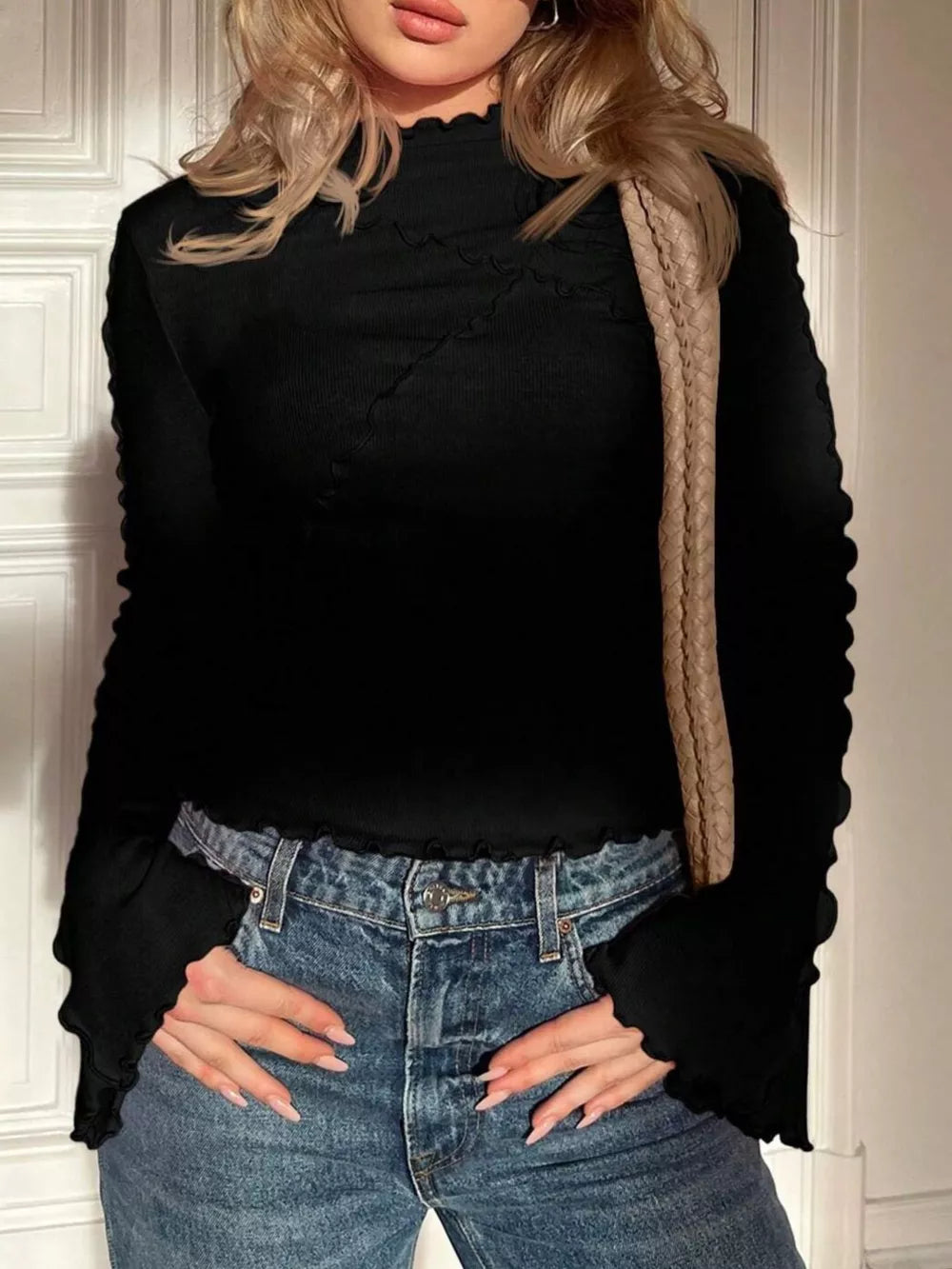 Black lettuce edge flare sleeve t-shirt with mock neck and ribbed texture.