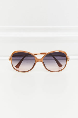 Oversized round frame sunglasses in caramel with gradient lenses and gold accents.