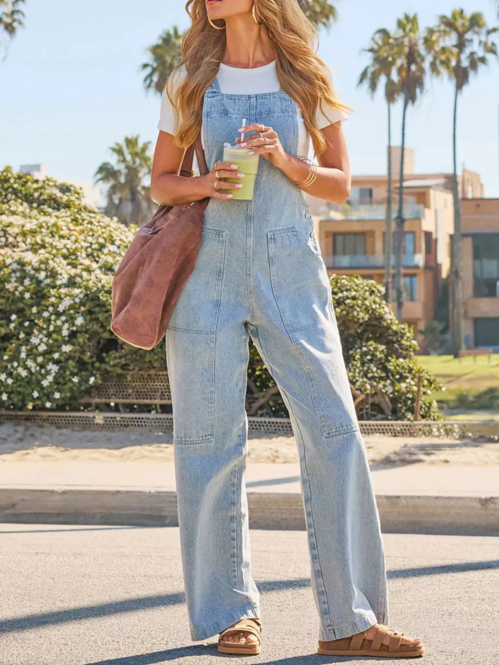 Light wash denim overalls with wide legs and utility pockets.
