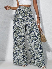 Palazzo trousers with tropical leaf print in navy, green, and white, 100% polyester.