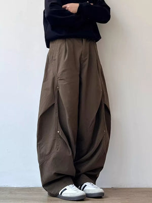 Men's brown loose fit cargo pants with large side pockets and button details.
