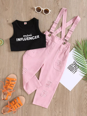 Black graphic tank top with white text and pink distressed denim overalls set
