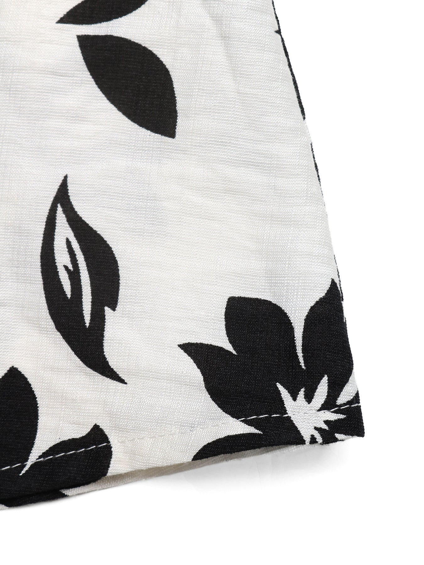 Maxi dress with black floral print on white textured fabric.
