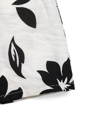 Maxi dress with black floral print on white textured fabric.