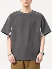 Men's dark gray textured t-shirt with contrast panels and crew neck.