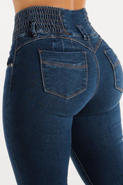 Dark wash skinny jeans with a sculpted, smocked waistband and button fly.