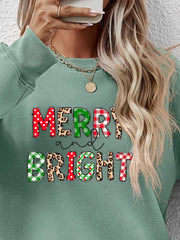Sage green sweatshirt with "Merry and Bright" graphic in festive patterns.