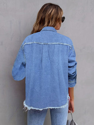 Light wash denim overshirt with frayed edges and buttoned front, styled casually.