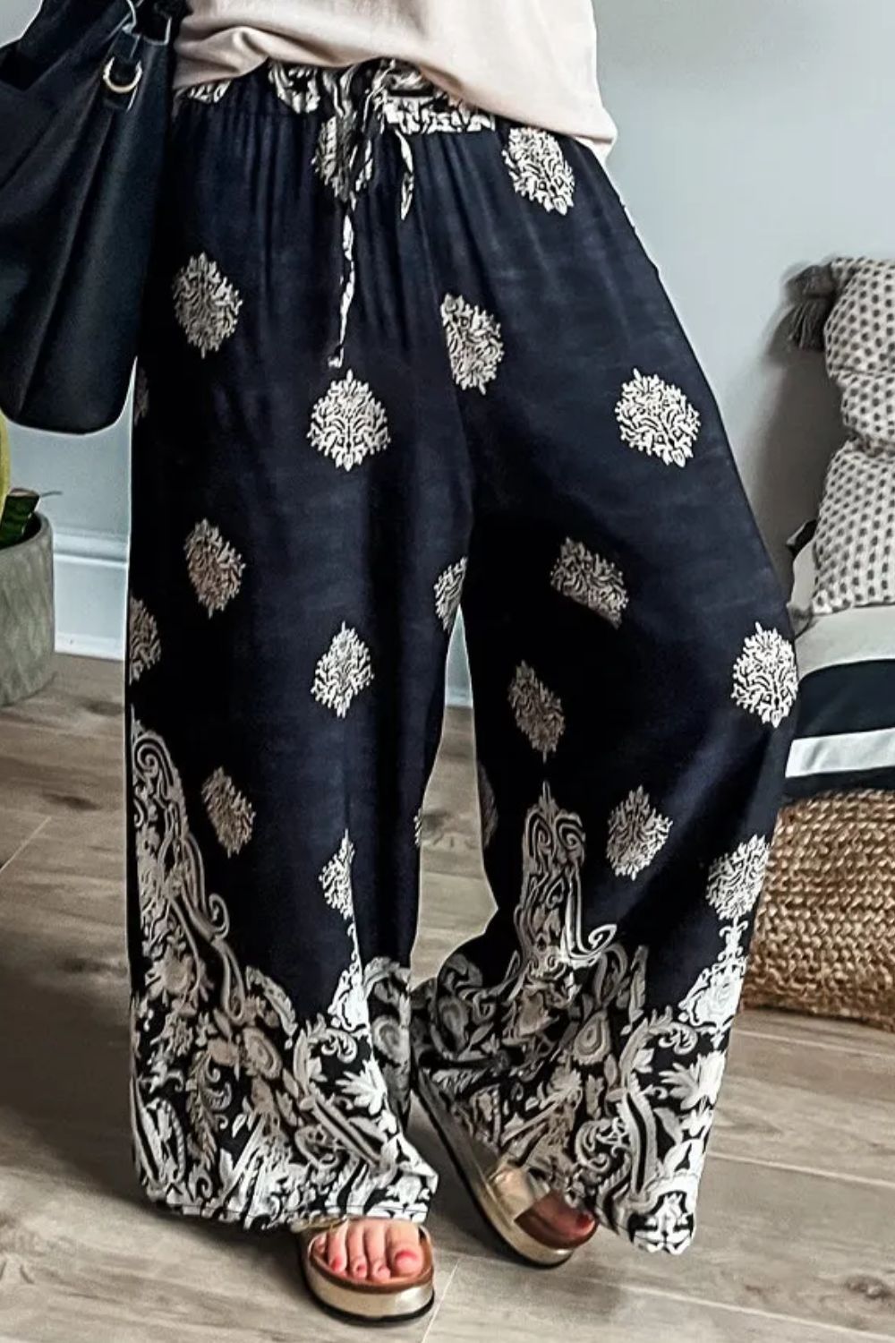 Black palazzo trousers with damask print and drawstring waist.