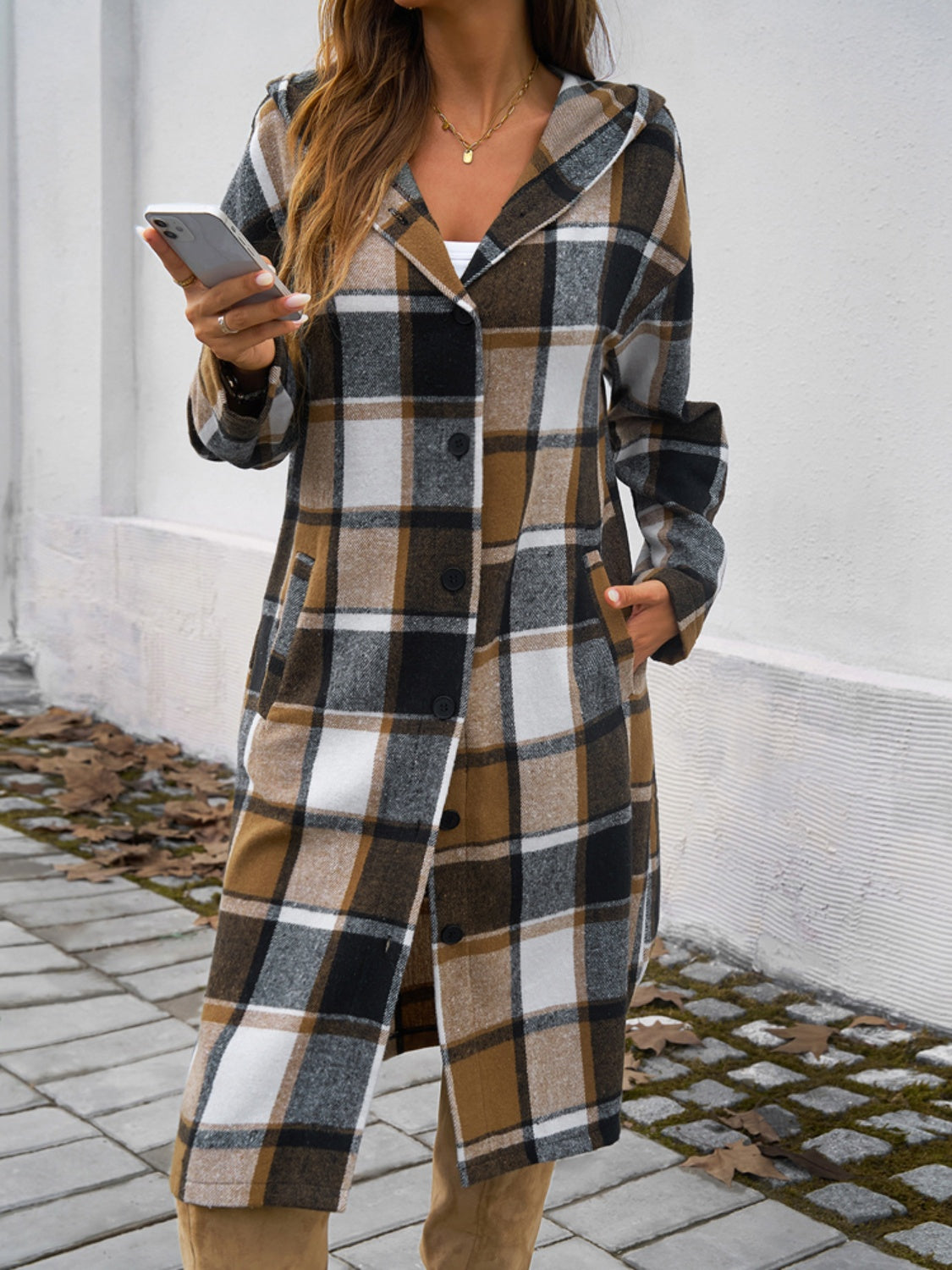 Checked plaid hooded duster coat in brown with button front and pockets.