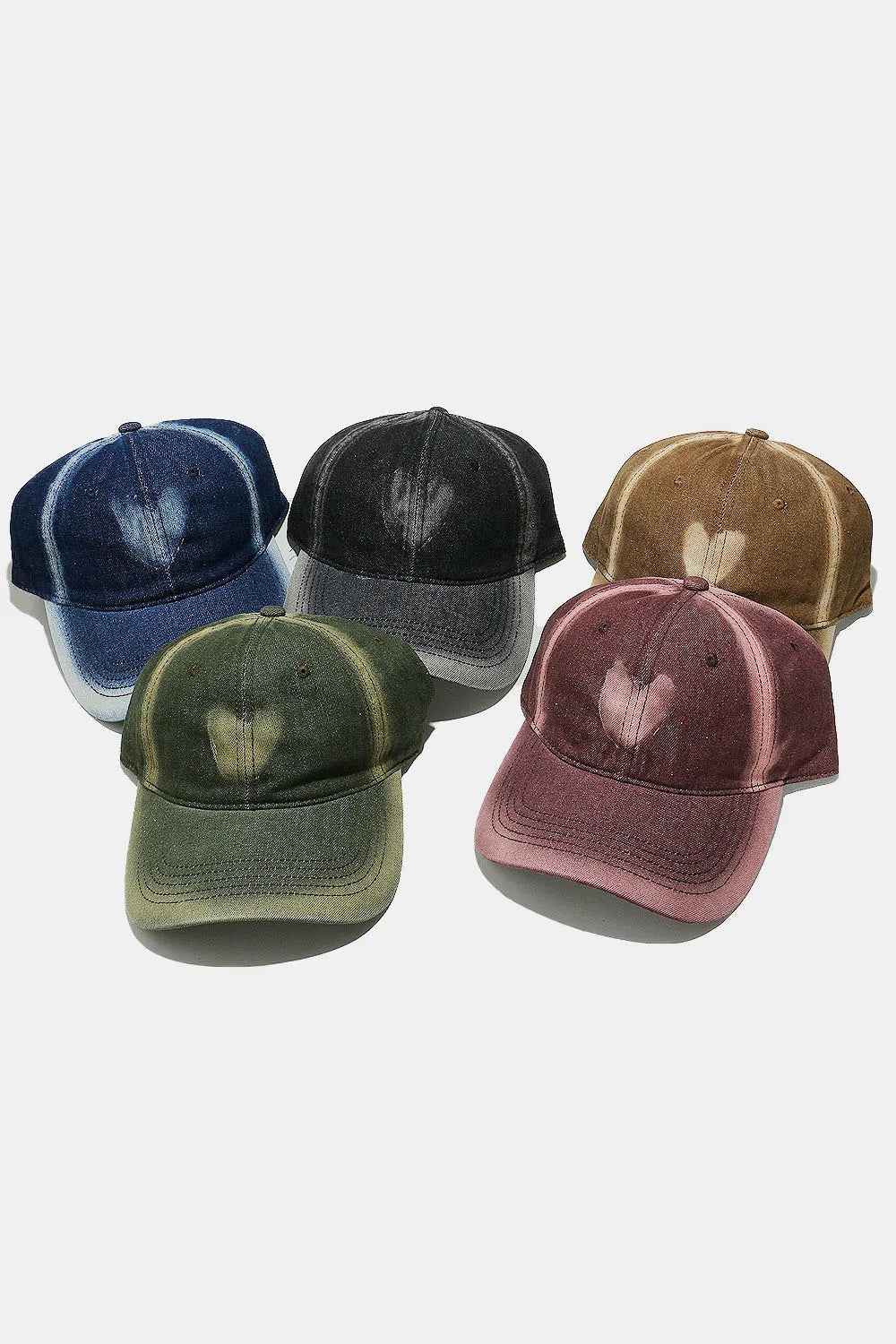 Bleached heart baseball caps in navy, black, caramel, moss, and dusty pink.