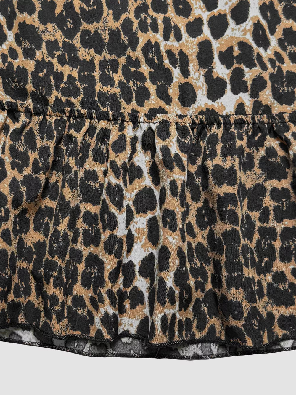 Leopard print cropped cami top with a ruffled hem and back tie detail.