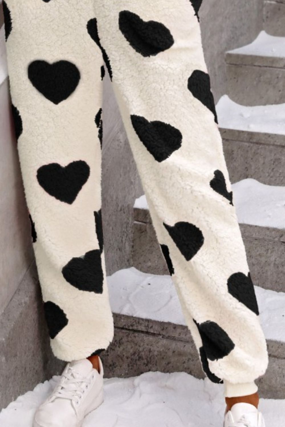 Heart-print sherpa onesie pants in cream with black hearts, cuffed ankles