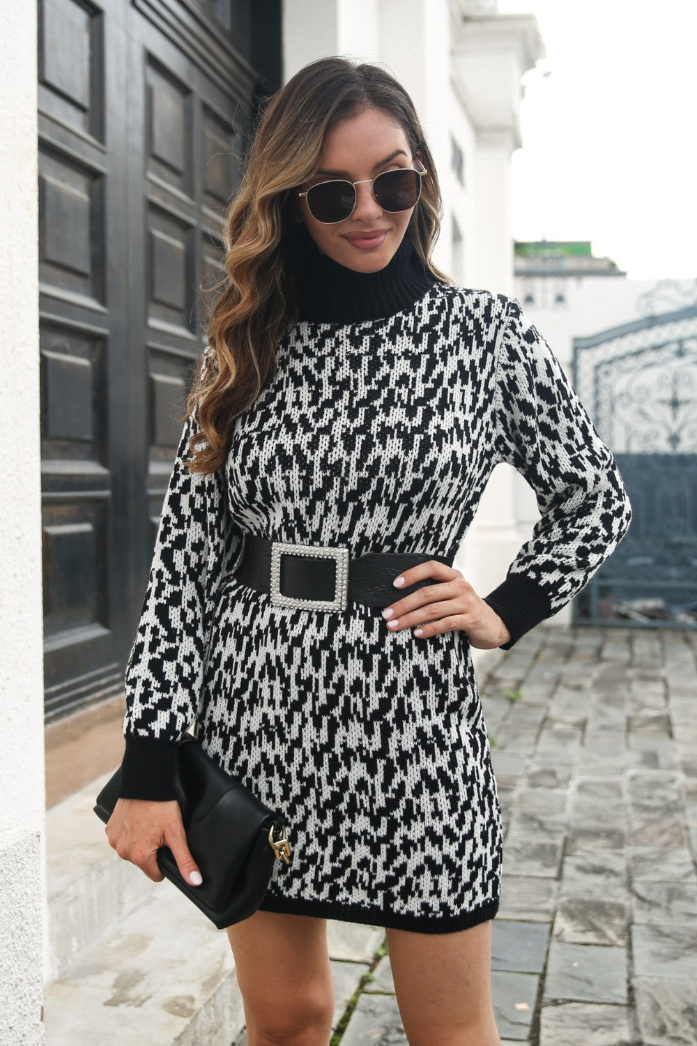Houndstooth knit turtleneck mini dress in black and white, with long sleeves and a black belt.
