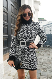Houndstooth knit turtleneck mini dress in black and white, with long sleeves and a black belt.