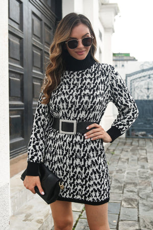 Houndstooth knit turtleneck mini dress in black and white, with long sleeves and a black belt.