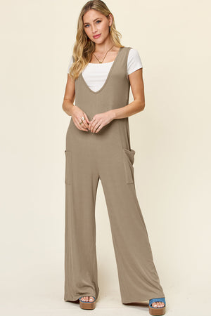 Mocha wide-leg jumpsuit with deep V-neck, pockets, and a white tee.