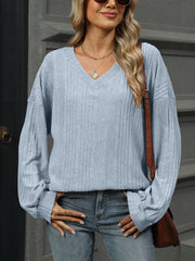 Light blue ribbed V-neck blouse with blouson sleeves and a relaxed fit.