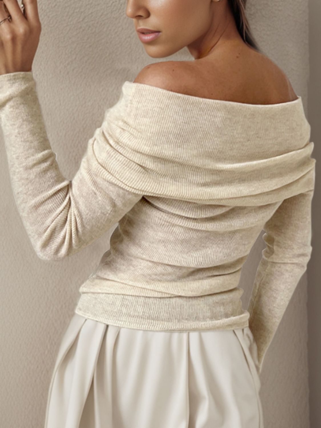 Ivory knit sweater with off-the-shoulder neckline and draped detail