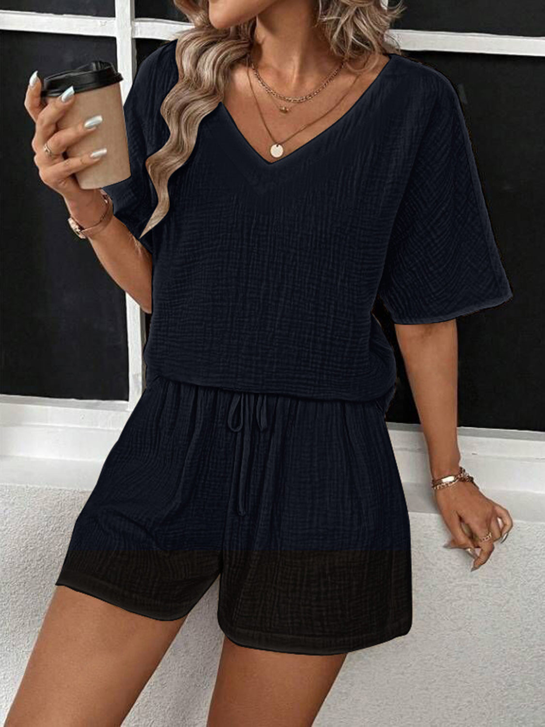Black textured gauze loungewear set with V-neck top and drawstring shorts.
