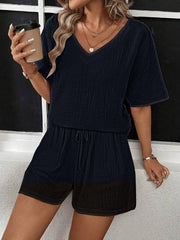 Black textured gauze loungewear set with V-neck top and drawstring shorts.