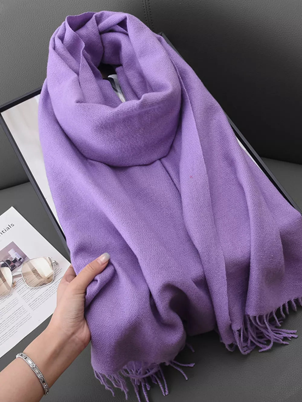 Elegant purple scarf with fringe detail, soft texture, and versatile styling options.