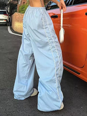 Light blue wide-leg maternity trousers with gathered waistband and white piping detail.