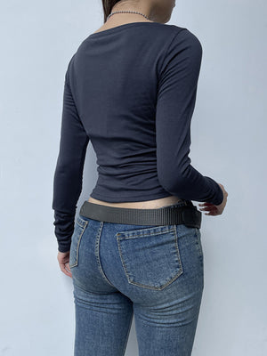 Dark blue long sleeve t-shirt with buttoned neckline and ruched sides, paired with jeans.