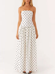 White polka dot strapless maxi dress with a tiered skirt.