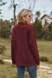 Burgundy textured cable knit polo top with long sleeves.