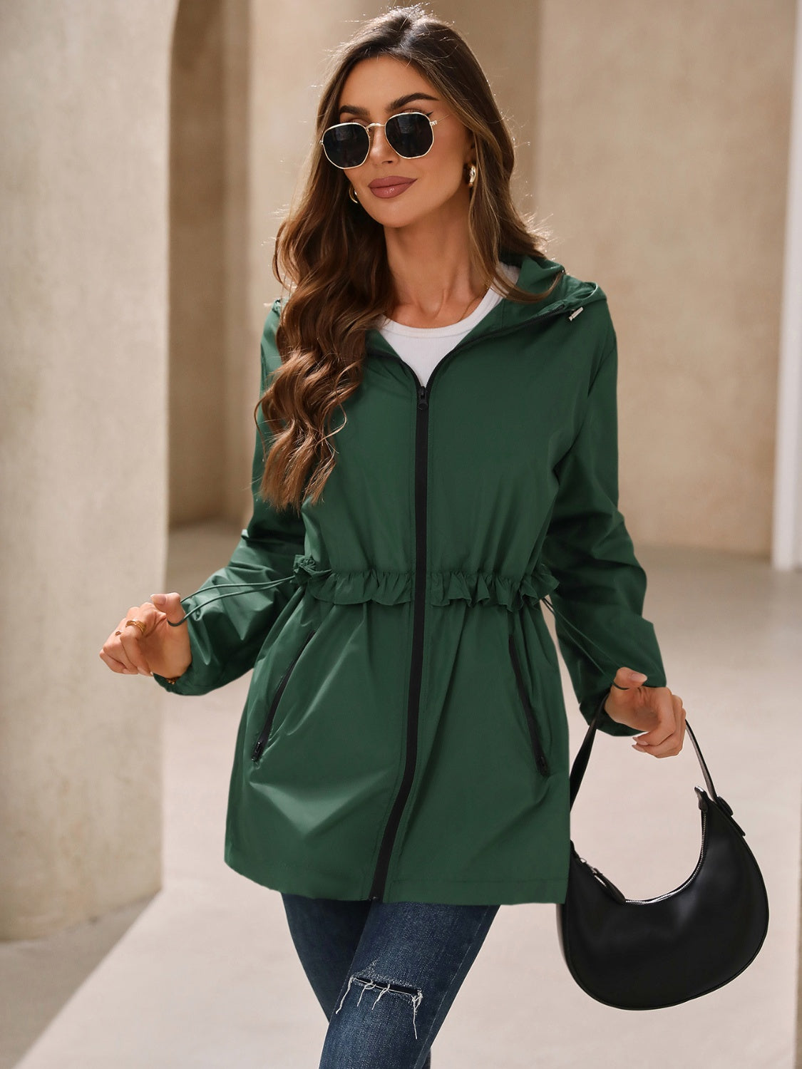 Dark green hooded windbreaker jacket with ruffled waistline and drawstring detail.