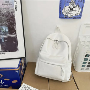 White leather backpack with front zip pocket and double zip top closure