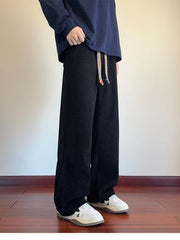 Men's black textured wide leg sweatpants with a colorful drawstring.