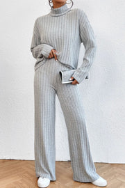Light gray ribbed knit turtleneck loungewear set with wide leg pants.