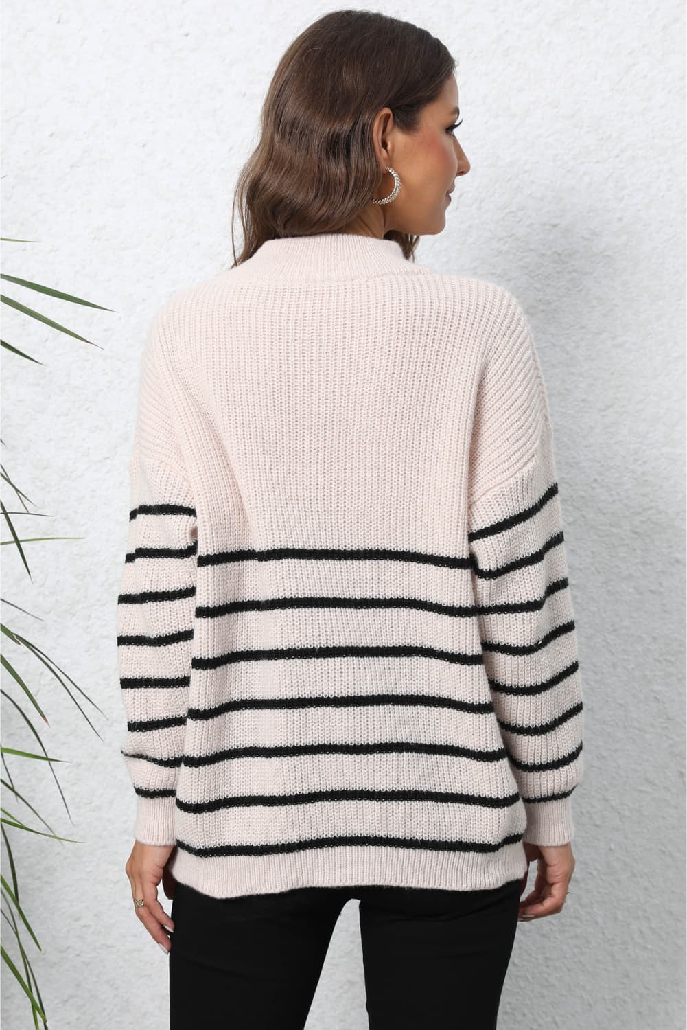 Beige striped knit sweater with black horizontal stripes on sleeves and lower body.