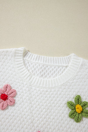 White knit sweater with crochet floral embellishments and a crew neck.