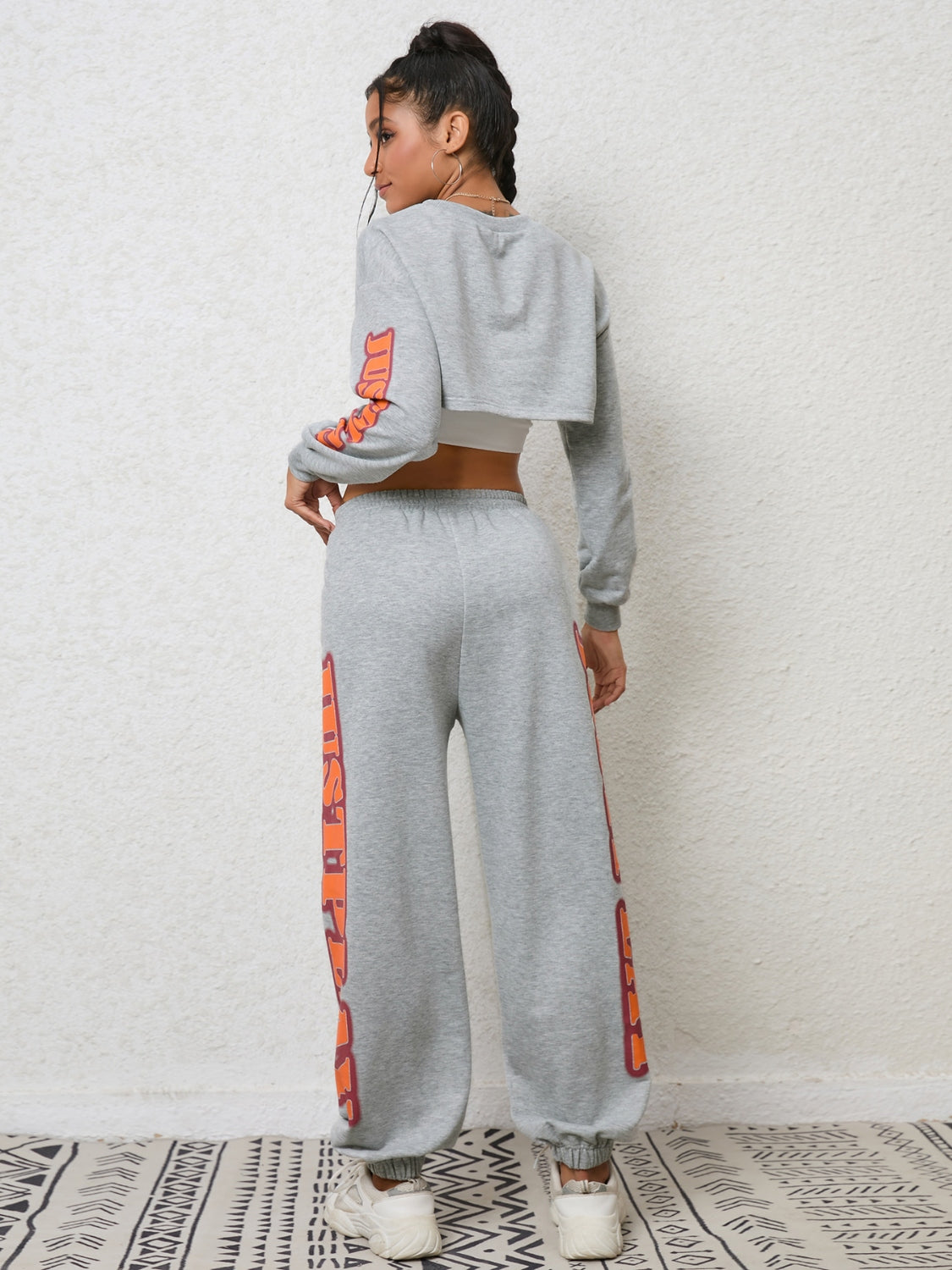 Heather gray crop sweatshirt and sweatpants set with orange graphic sleeve and leg details