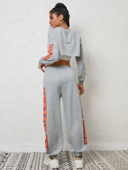 Heather gray crop sweatshirt and sweatpants set with orange graphic sleeve and leg details