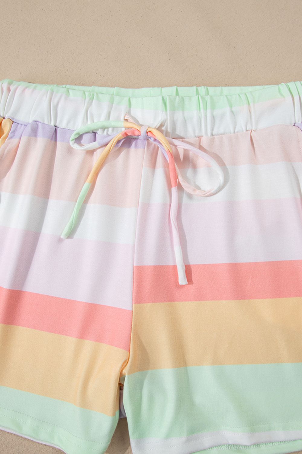 Striped lounge shorts with drawstring waist and pastel rainbow colors.