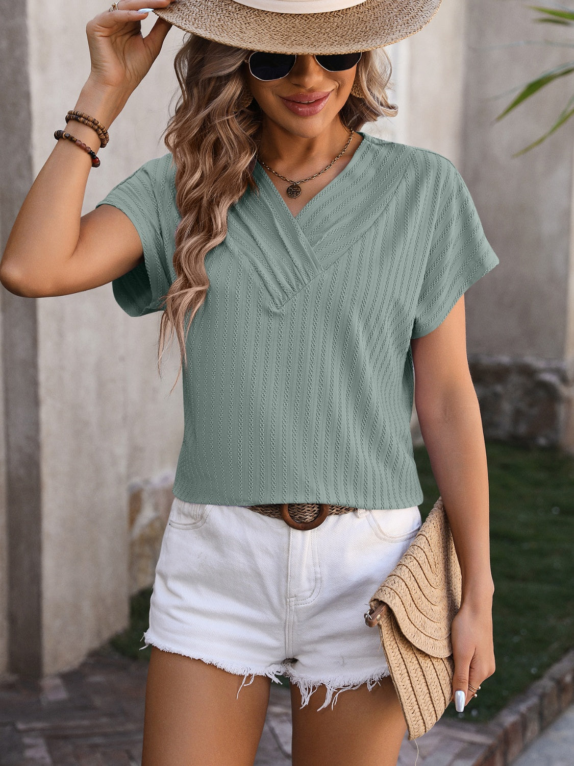 Sage green textured V-neck tee with short sleeves and subtle vertical ribbing.