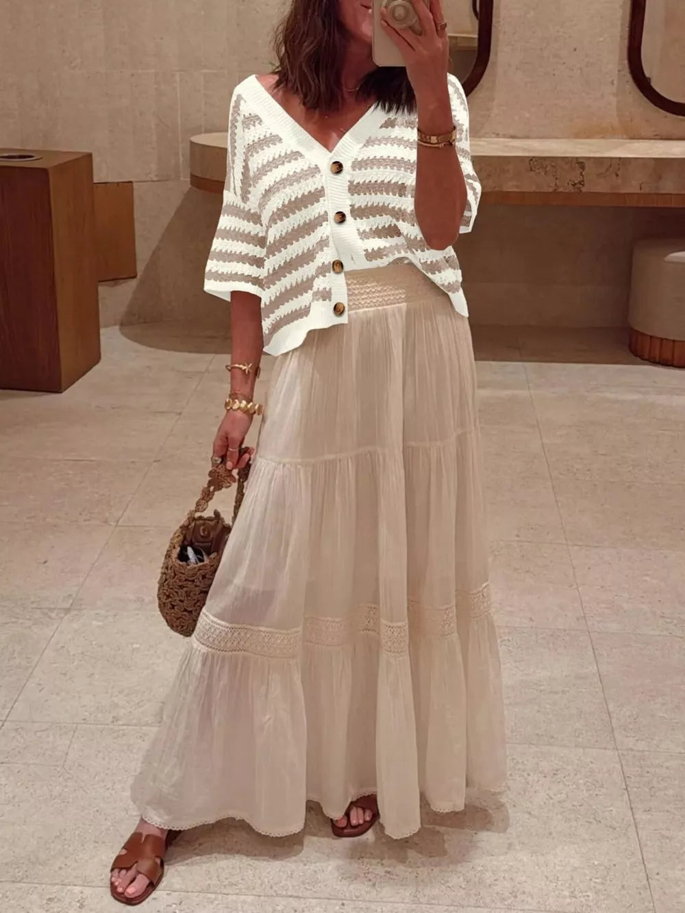 Cropped striped knit cardigan with buttons and V-neck, styled with a maxi skirt.