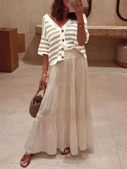 Cropped striped knit cardigan with buttons and V-neck, styled with a maxi skirt.
