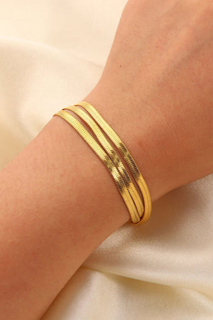 Triple gold herringbone chain bracelet crafted with a flat, flexible design.