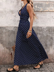 Navy polka dot maxi dress with halter neck and cinched waist.