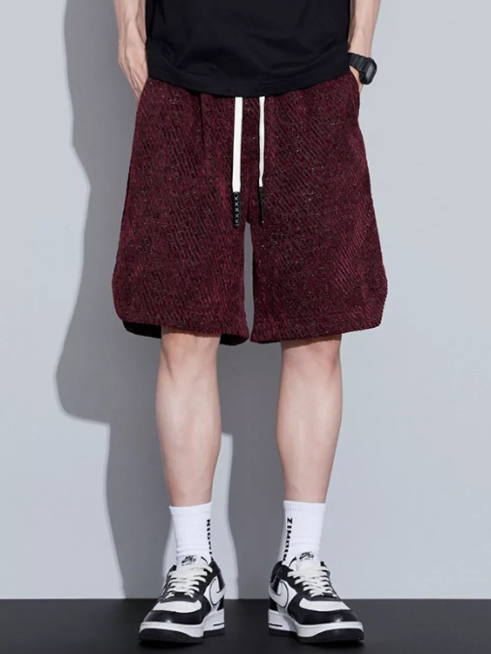 Burgundy textured drawstring shorts with a relaxed fit and white drawstrings.