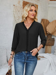 Black eyelet trimmed V-neck blouse with lace detail on sleeves and neckline.