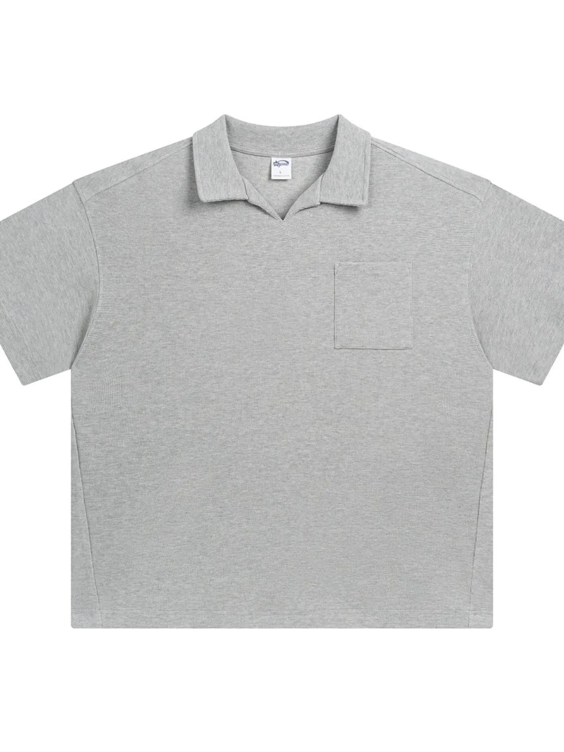 Boxy knit polo shirt in gray with a patch pocket and open collar.